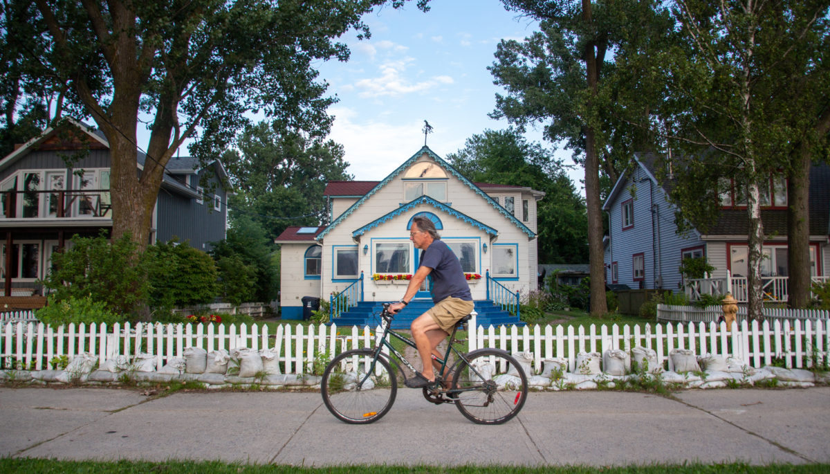 Man biking in front of cottage