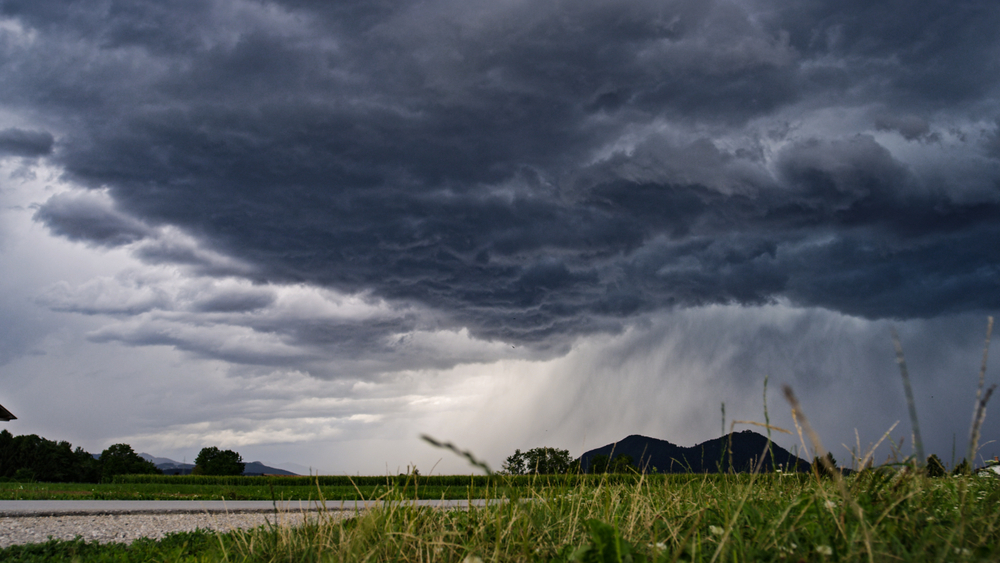 A prairie field with dark clouds above it