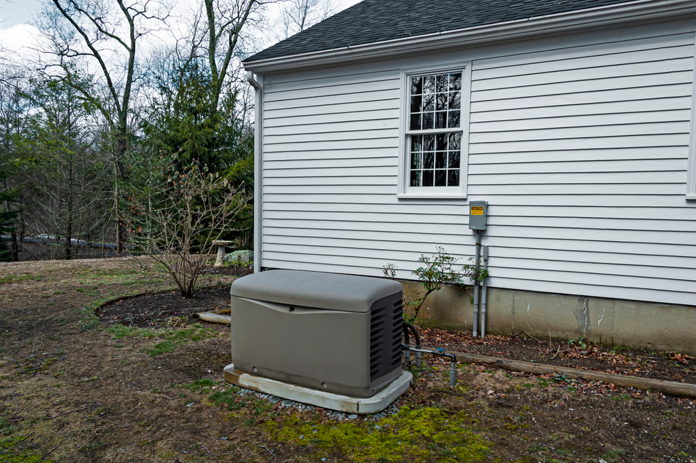 A residential standby generator installed on a concrete pad.