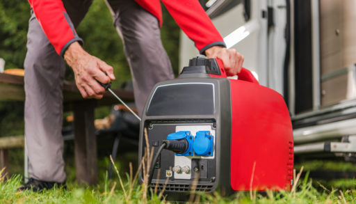 A man firing up a gas powered portable inverter generator.