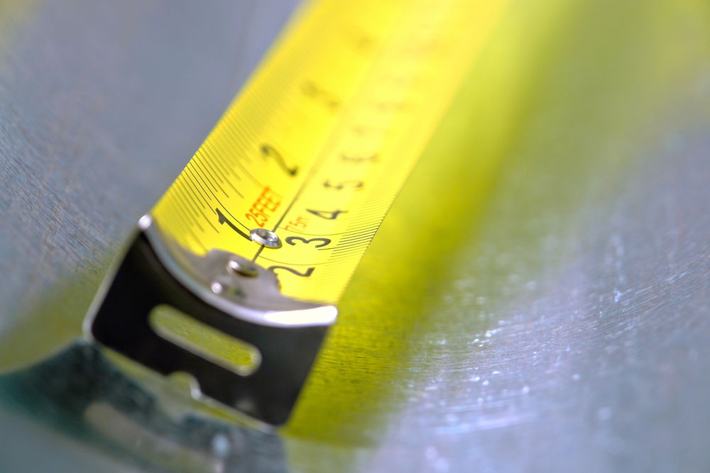 Self-retracting construction tape measure with floating tang in inch and centimetre markings, hand tools