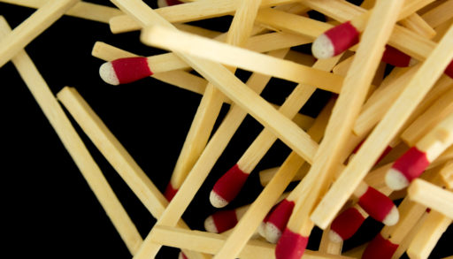 A pile of strike-anywhere matches against a black background