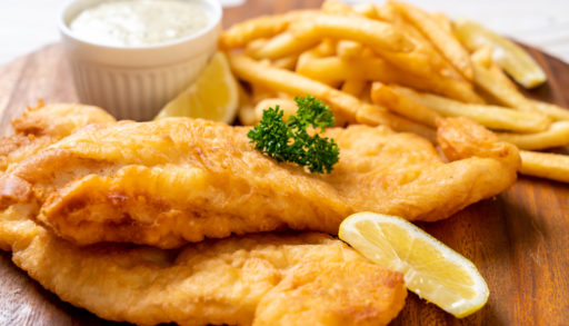 A close-up of fish and chips with a slice of lemon on the side.