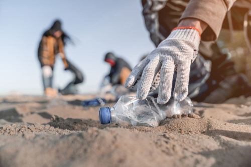 Volunteer man collecting trash on the beach. Ecology concept, ecosystem