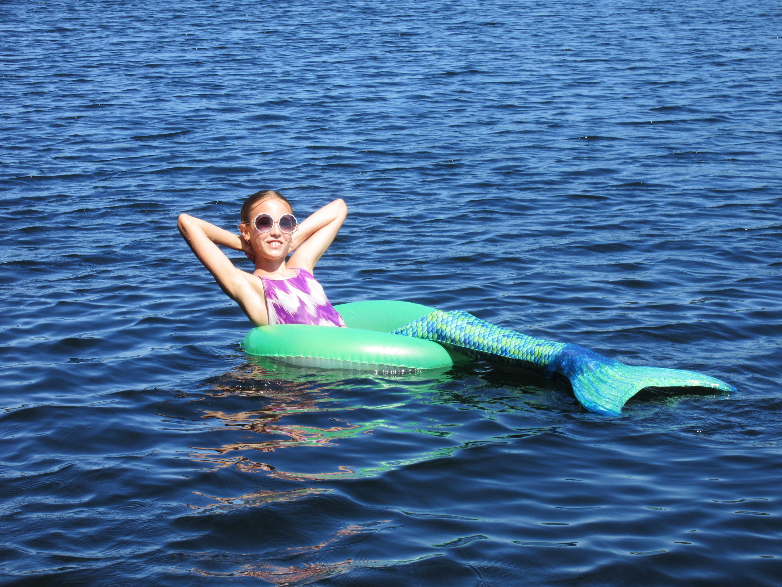 Girl dressed as mermaid relaxing on water