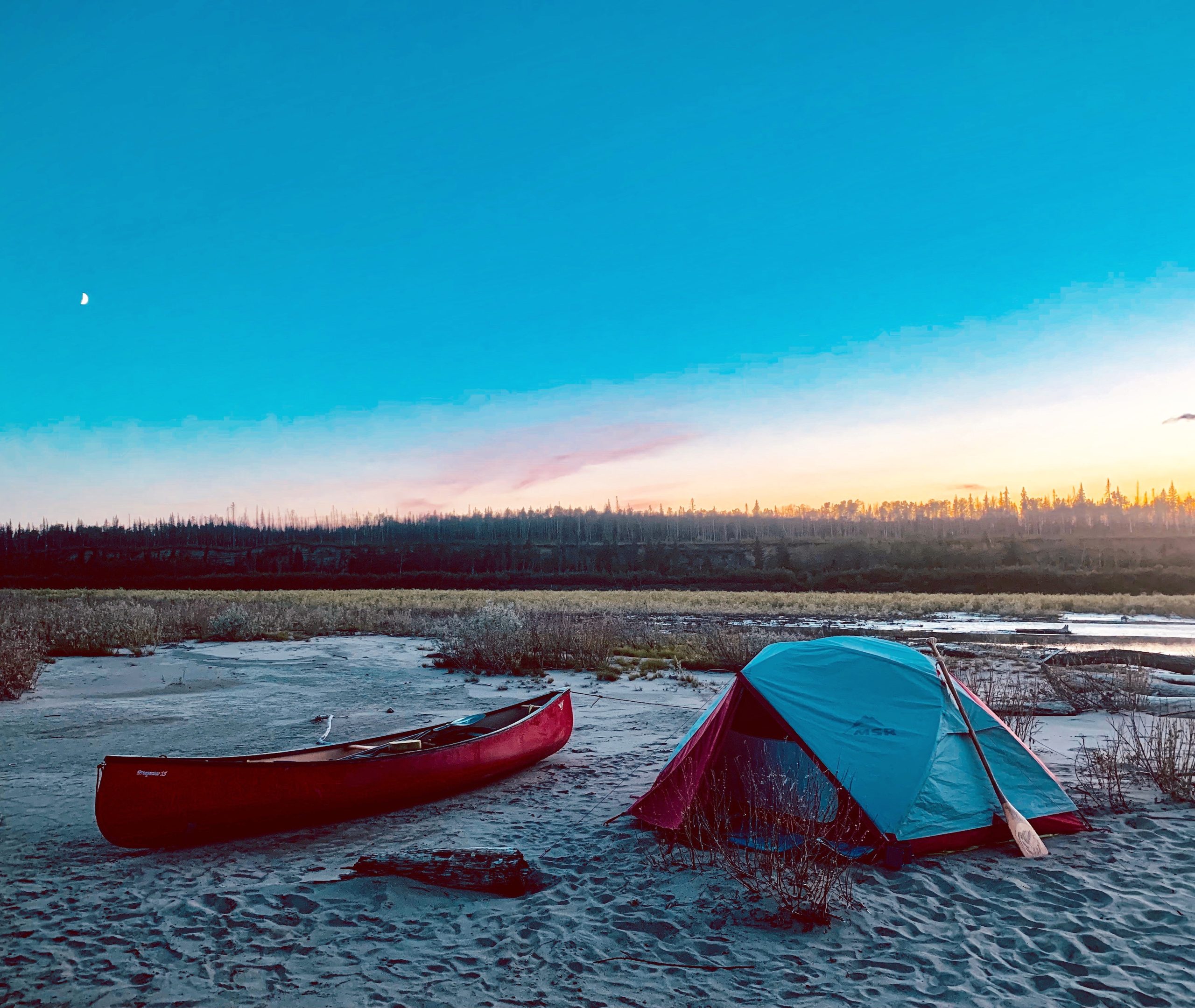 Shot of riverside camp spot with a tent and canoe