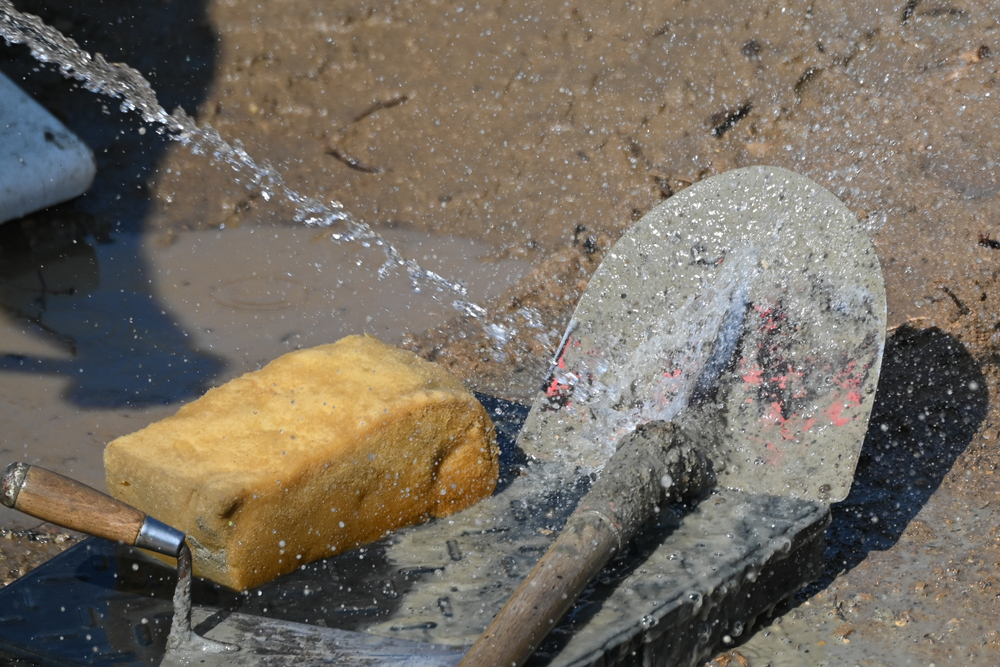 Concrete construction contractor washing tools on a new urban road street project