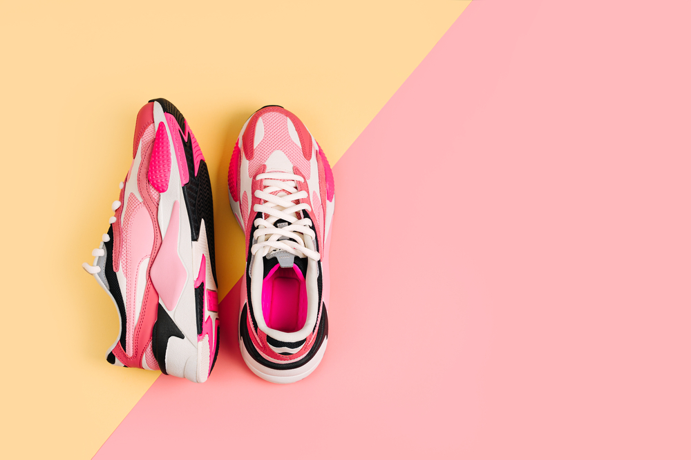 Bright female sneakers on pink background. Fashion blog or magazine concept. Women's shoes, trendy sneakers, fashion, style, lifestyle. Flat lay top view copy space minimal background. measure
