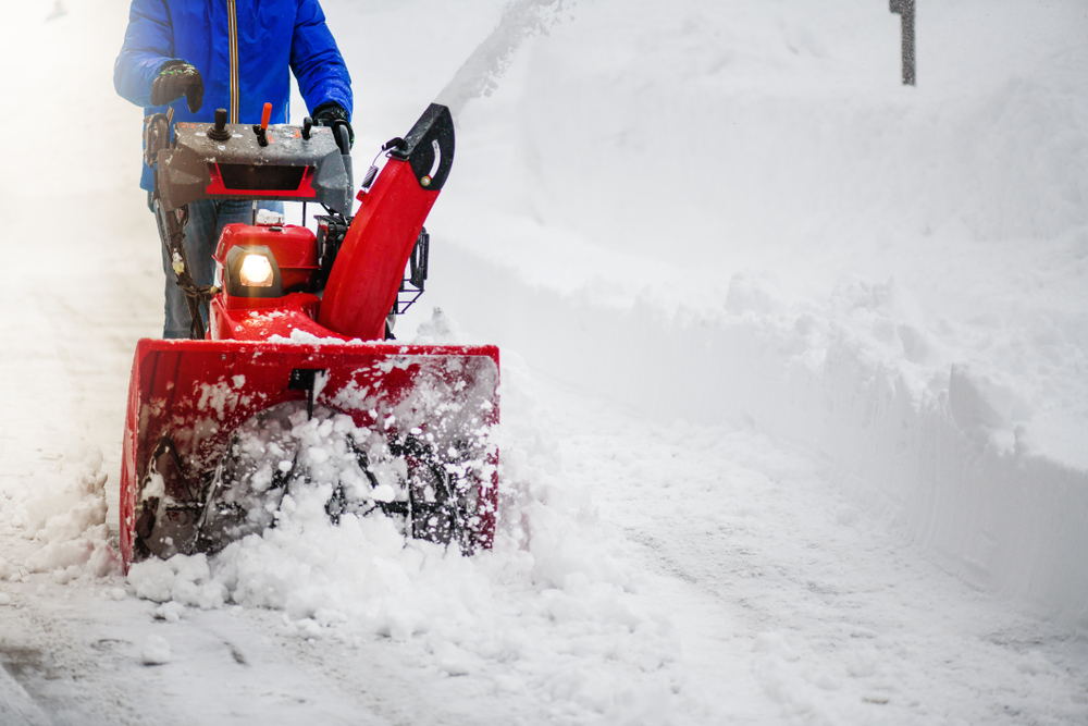Close-up of a man using a snowblower