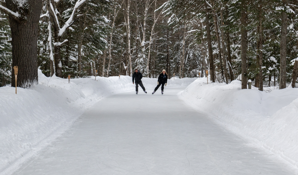 man and woman skating through forest
