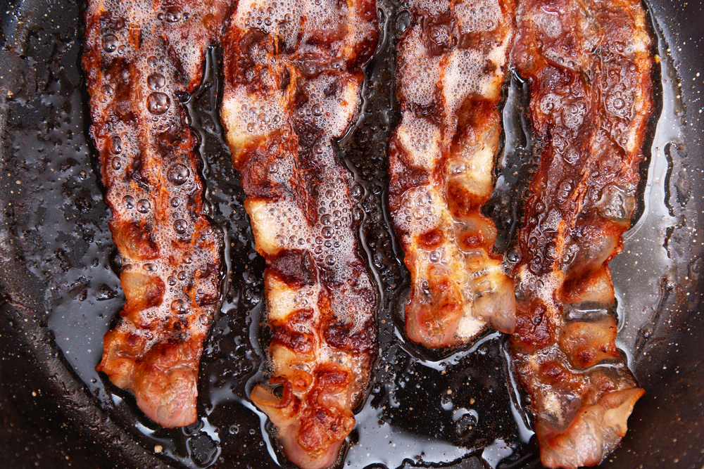close up of bacon frying in pan