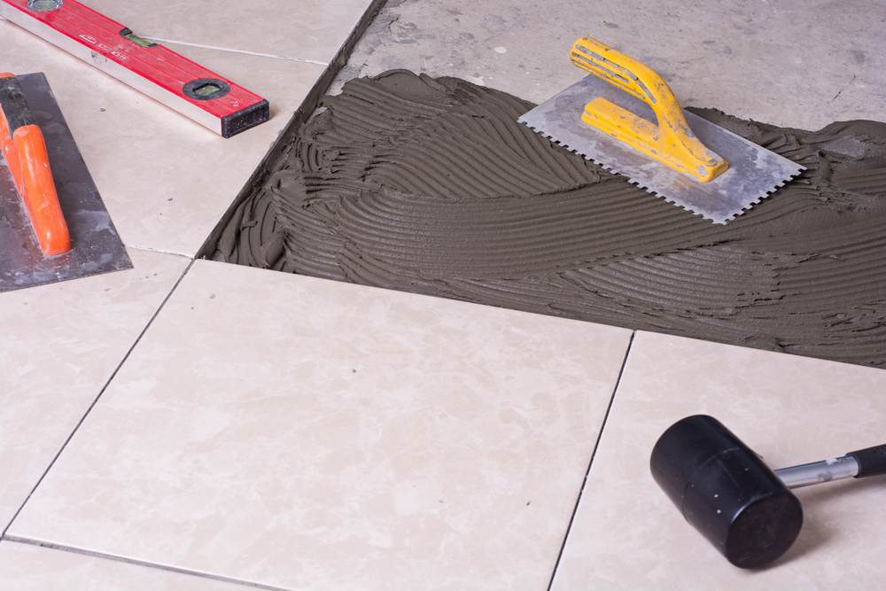 Notched trowel, spacers and prepared setting compound for tile, replacing a cracked tile