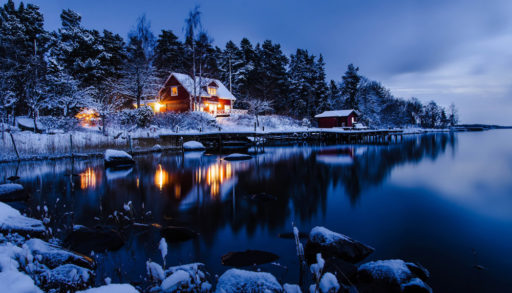 An night shot of a cabin covered in snow
