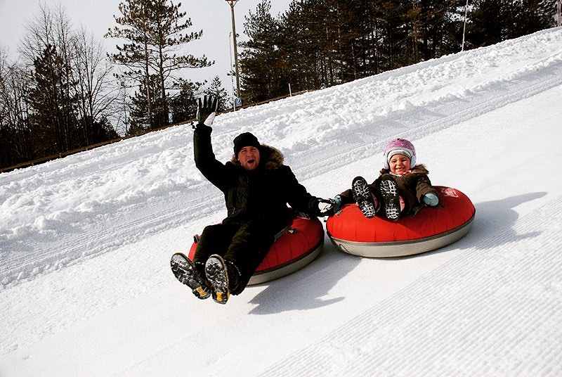 Man waving from snow tube