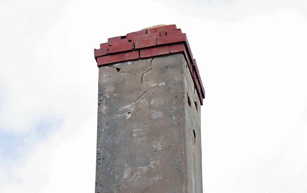A cracked chimney with a red cap