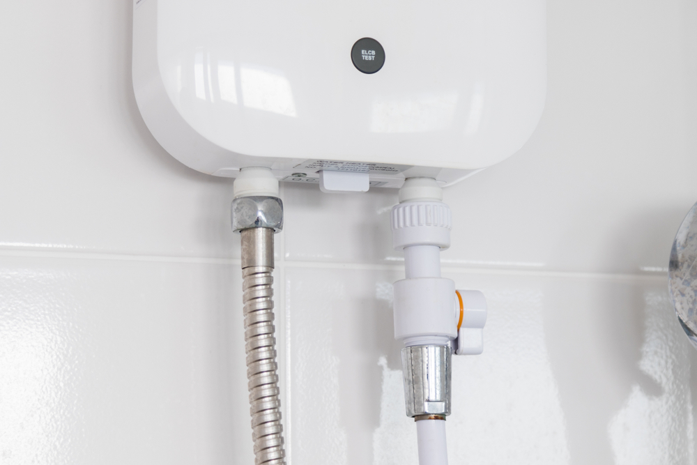A tankless hot water heater mounted to a white wall