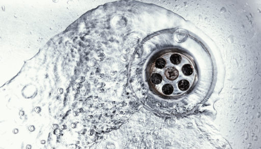 Water circling down a stainless steel kitchen sink drain