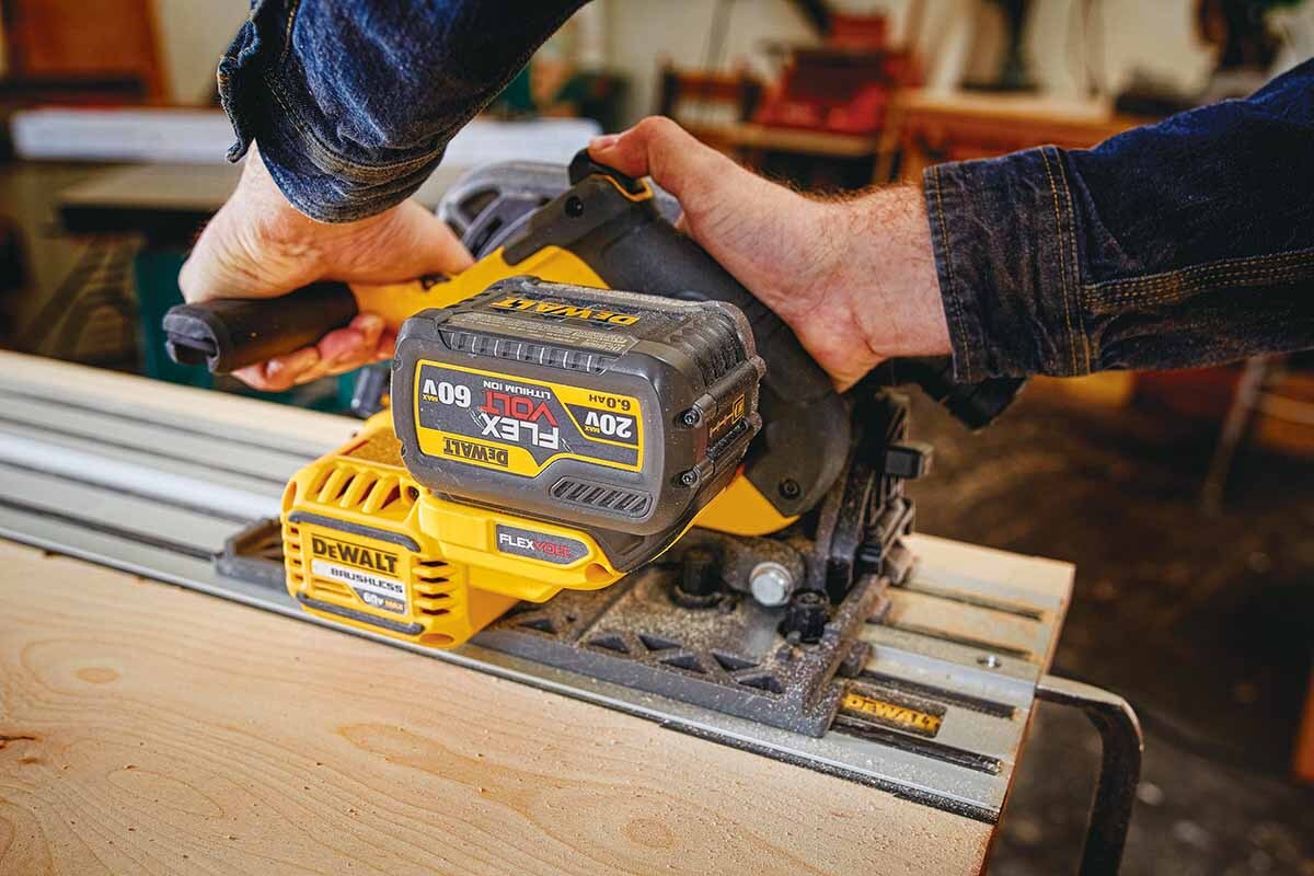 man using a track saw in a workshop
