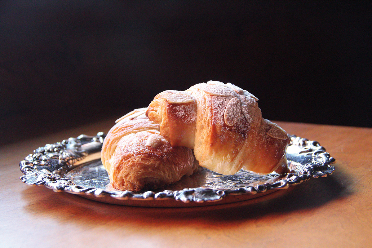 croissants with almonds and dusted sugar on a plate