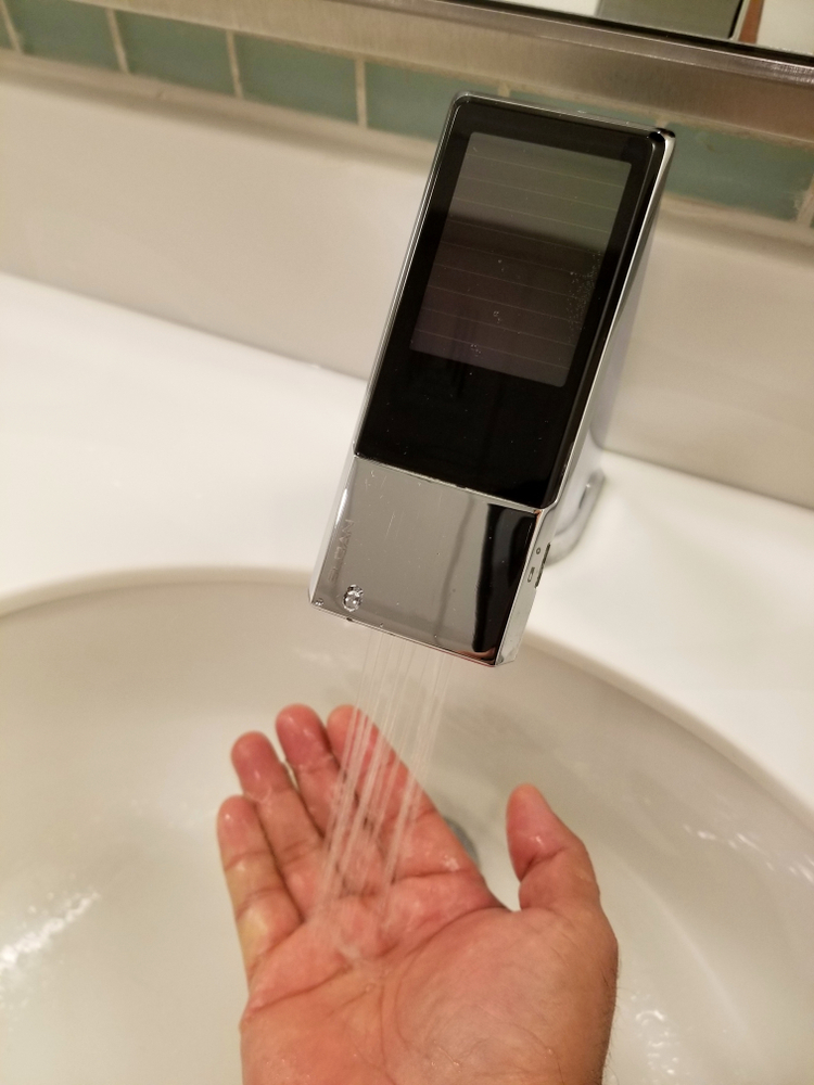 A hand activating a touchless faucet