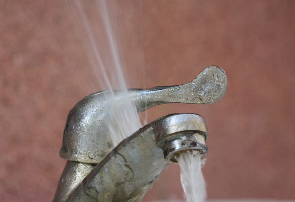 A faulty faucet spraying water into the air