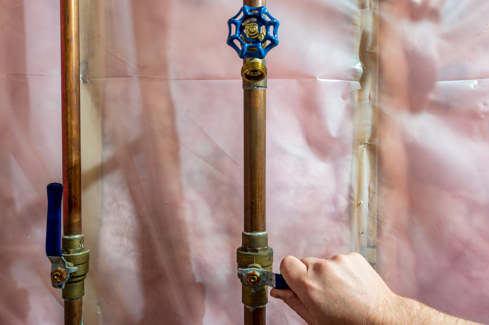 Close-up of a hand turning the water shut-off valve
