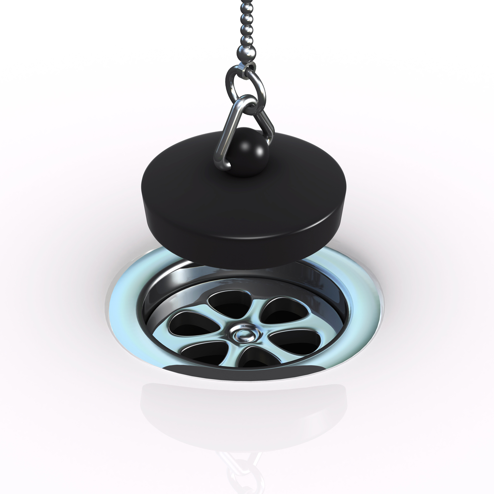 A black plug being lowered into a drain