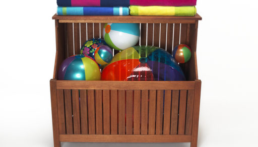 An outdoor bin filled with beach balls and towels