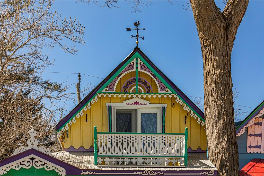Close-up of the upper-level balcony with a white, wood-carved railing.