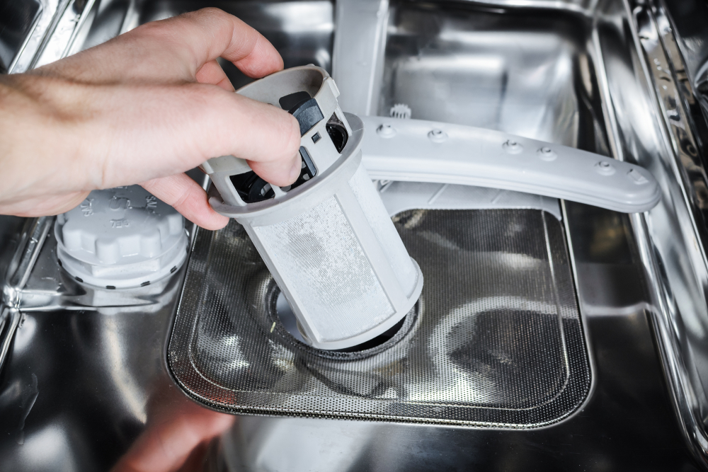 Close up of hands removing the dishwasher filter