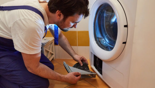 A man cleaning the lint trap from a clothes dryer