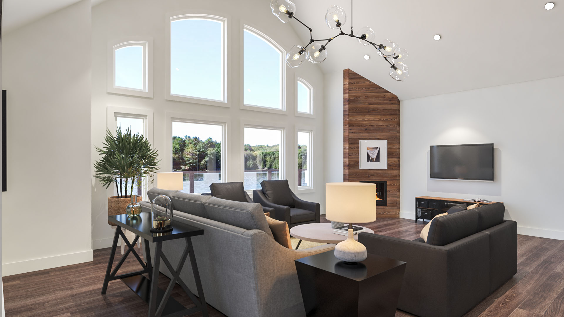 A large living room with a grey couch, a wood accent fireplace, and big windows with a view of the lake.