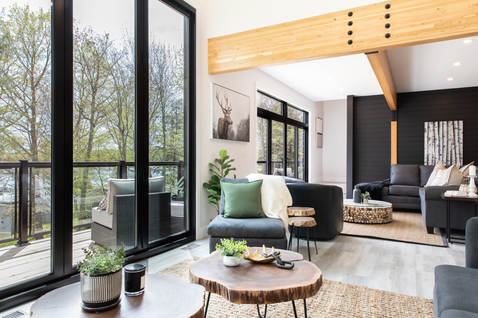 A bright space with seating and large windows that is open to a living room beyond it.