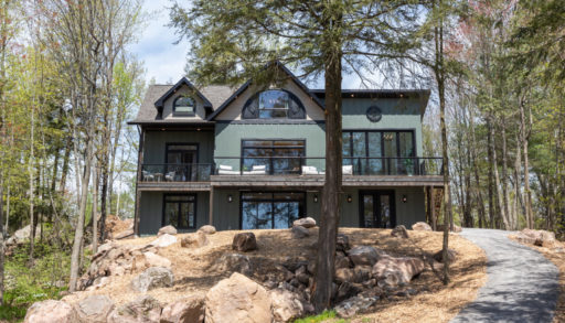 A large cottage with a green and brown exterior.