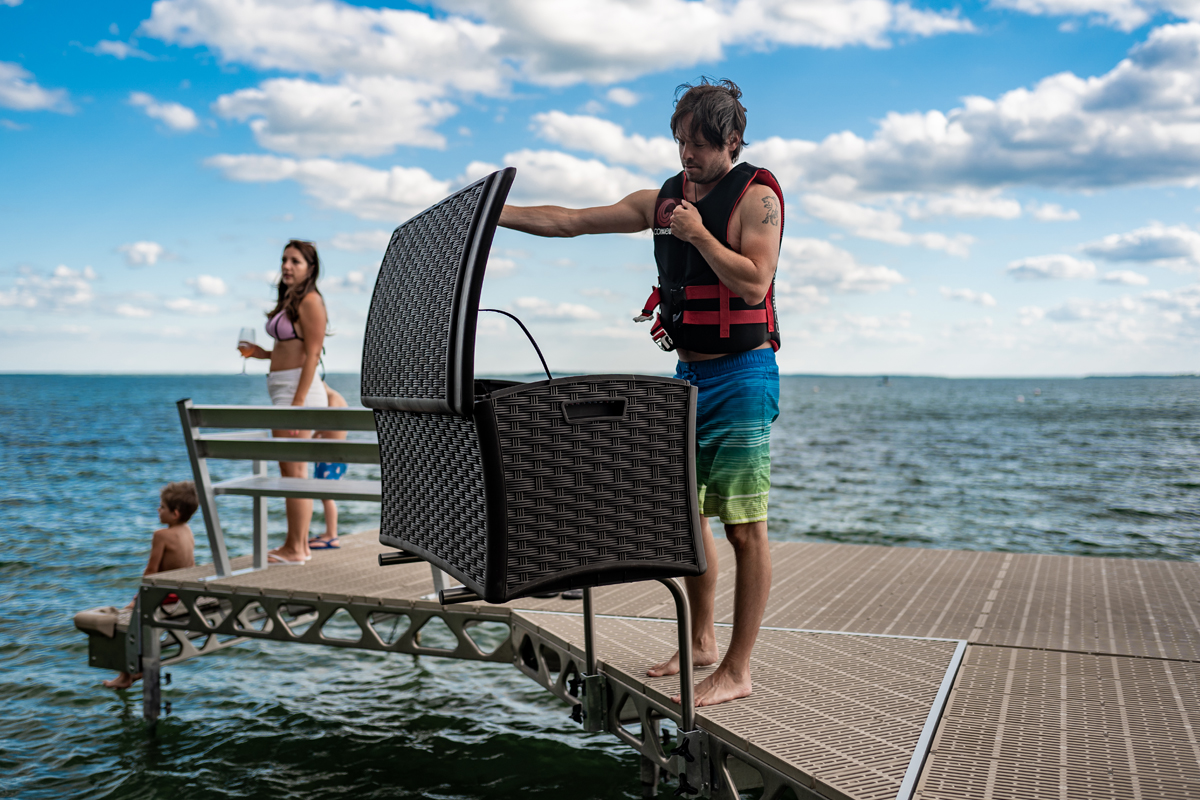 A man opening a built-in CanadaDocks dock storage box