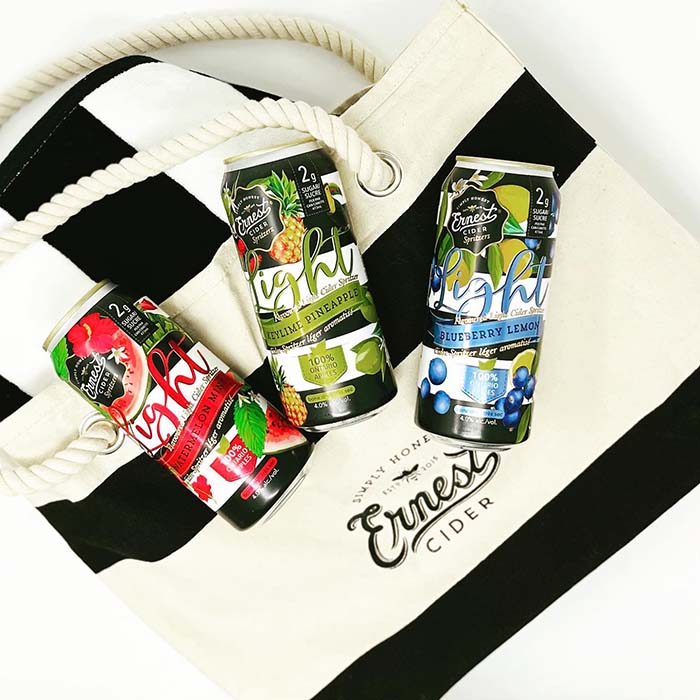 ernest cider flavours laying on top of a striped Ernest bag