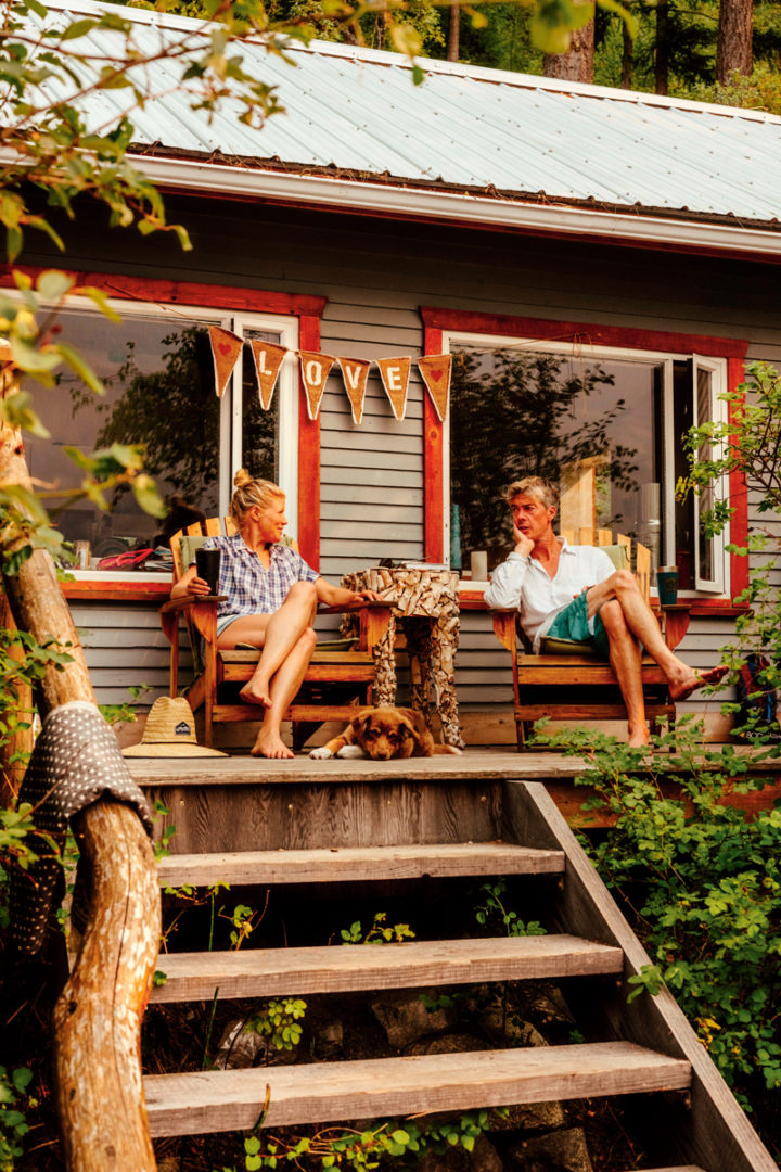 Catherin and Sholto sit on the porch of their Anderson Lake cabin