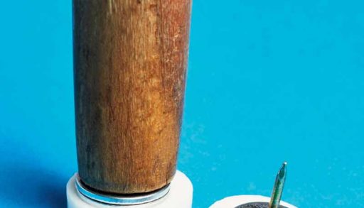 The bottom of a chair leg, with furniture glides and washers to be attached.