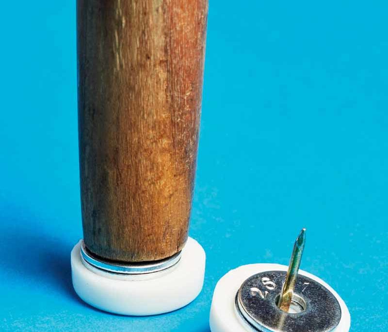 The bottom of a chair leg, with furniture glides and washers to be attached.
