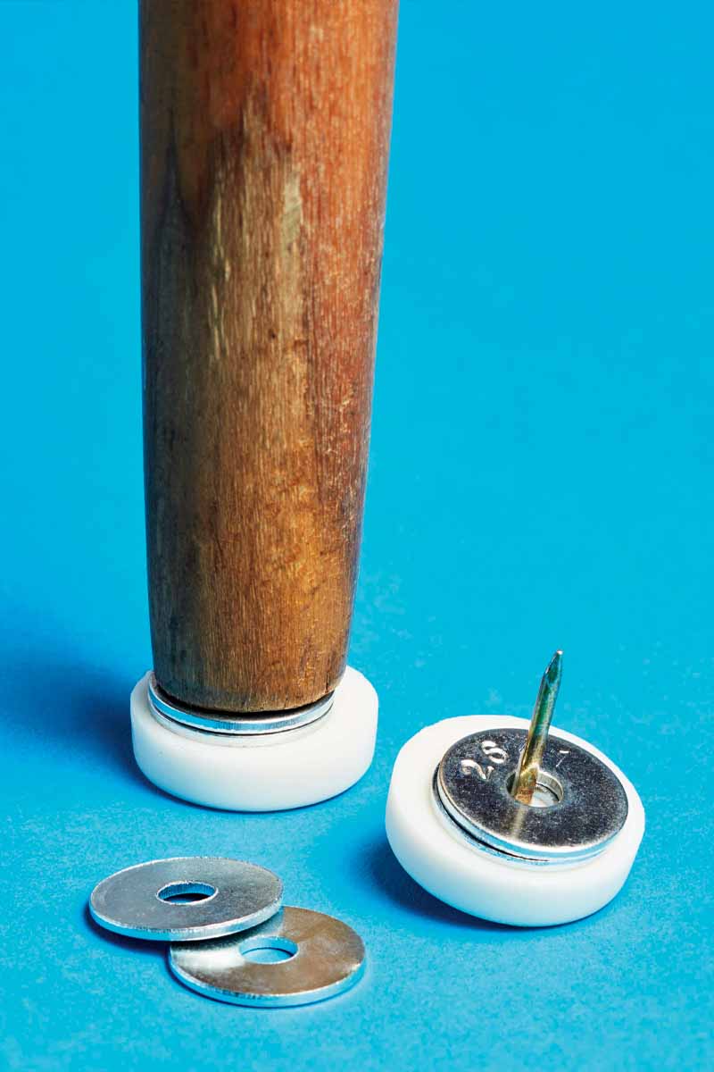 The bottom of a chair leg, with furniture glides and washers to be attached.