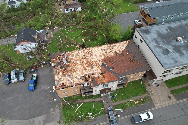 A bird's eye view shot of a house with its roof shingles completely torn away.