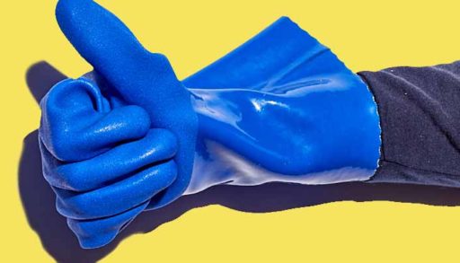 A hand wearing a cobalt blue PVC gauntlet chemical resistant glove against a yellow background.