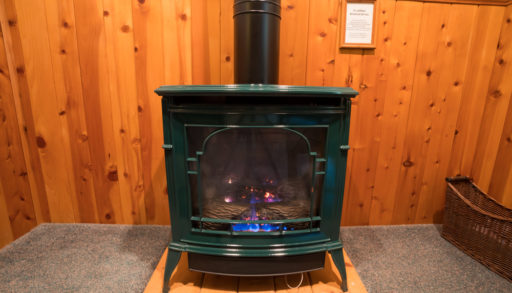 A woodstove set on a concrete pad in a basement