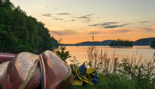 Sunset on Lac du Poisson Blanc (Whitefish Lake) with canoe on the shore of the lake. This regional park is located in Outaouais region of Quebec (Canada)