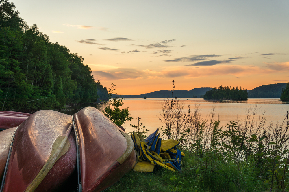Sunset on Lac du Poisson Blanc (Whitefish Lake) with canoe on the shore of the lake. This regional park is located in Outaouais region of Quebec (Canada)