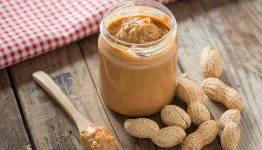 A jar of peanut butter on a wooden table