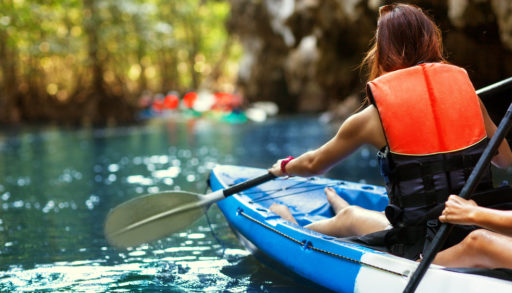 A woman paddling a tandem kayak