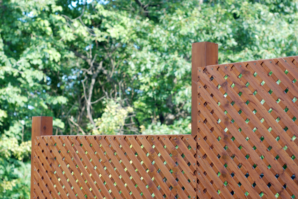A lattice fence with trees in the background
