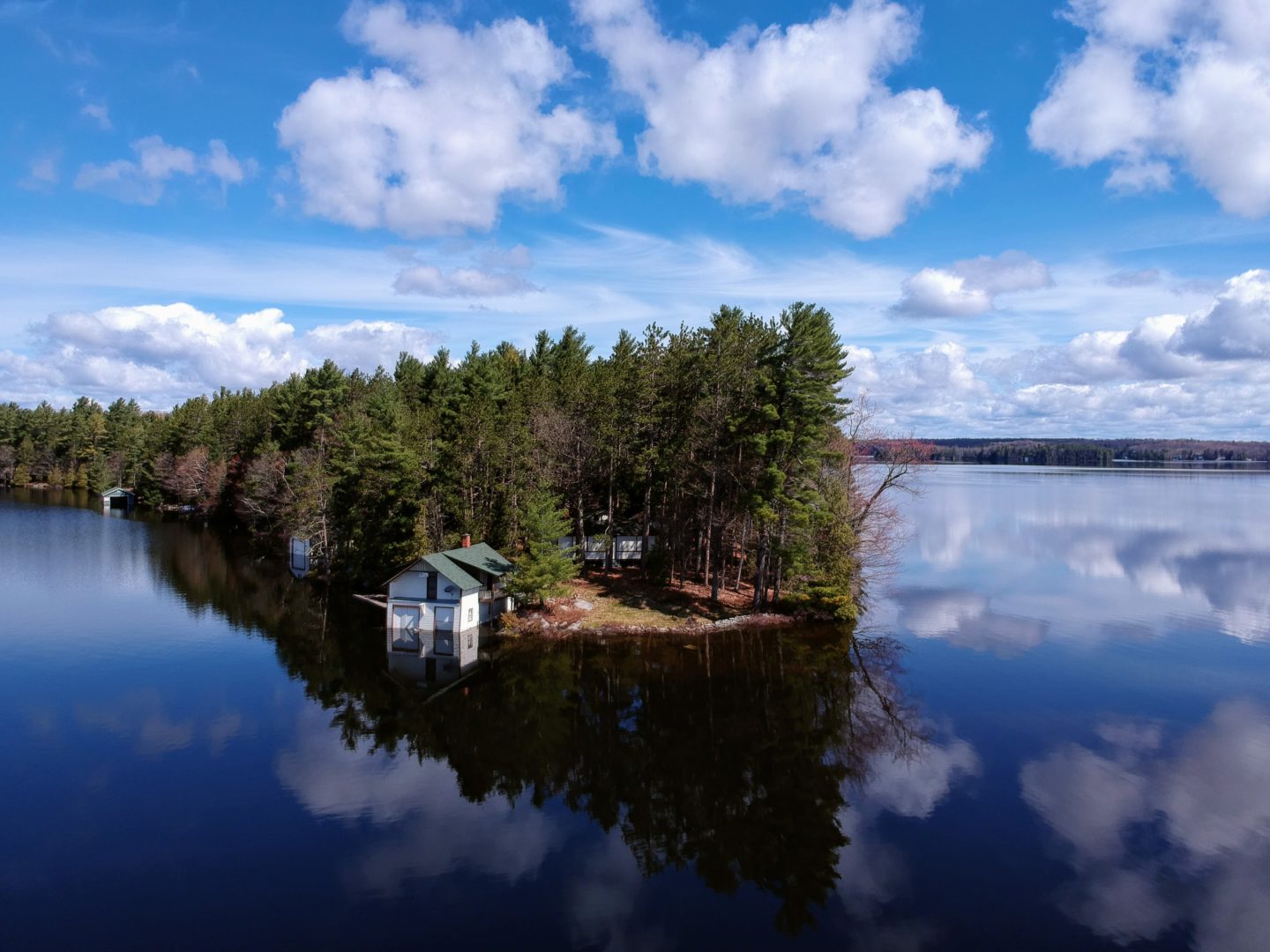 Photo contest entry of an original cottage on an island covered by trees.