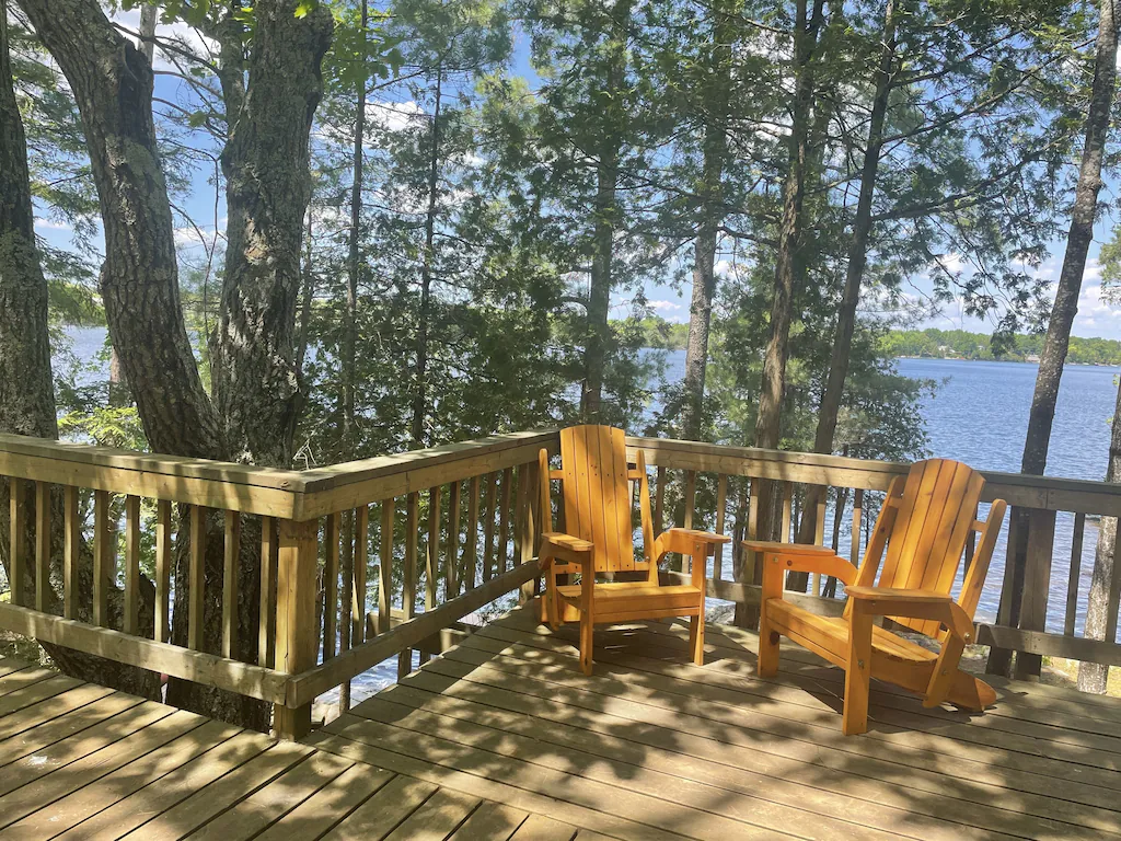 Large accessible wood deck with two Muskoka chairs, over looking Head Lake.